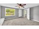 Well-lit bedroom with neutral walls, carpet, ceiling fan, and a large window at 4301 Hidden Valley Rd, Decatur, GA 30035