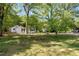 View of a cozy home nestled among mature trees on a spacious lot with a well-manicured lawn at 4301 Hidden Valley Rd, Decatur, GA 30035