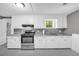 Clean kitchen with white cabinets, modern appliances, and light countertops at 4301 Hidden Valley Rd, Decatur, GA 30035