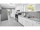 Functional kitchen with white cabinets, modern appliances, and brick flooring at 4301 Hidden Valley Rd, Decatur, GA 30035