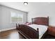Bedroom features a hardwood floor, light gray walls, a window, and a large bed at 4466 Woodland Bank Blvd, Buford, GA 30518