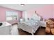This pink bedroom is cute, with plenty of light and hardwood floors at 4466 Woodland Bank Blvd, Buford, GA 30518