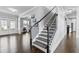 Inviting foyer with a staircase, dark hardwood floors, and views of the front door and entryway at 4466 Woodland Bank Blvd, Buford, GA 30518