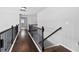 Hallway with hardwood floors, dark railing, and gray walls at 4466 Woodland Bank Blvd, Buford, GA 30518