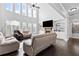 Bright living room featuring a fireplace, hardwood floors, large windows, and built-in shelving at 4466 Woodland Bank Blvd, Buford, GA 30518