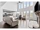 Bright living room featuring high ceilings, large windows, hardwood floors, and a stone fireplace at 4466 Woodland Bank Blvd, Buford, GA 30518