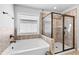 This bathroom features a soaking tub and glass shower with tile surround at 4466 Woodland Bank Blvd, Buford, GA 30518