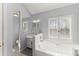 Bright bathroom featuring a double vanity, soaking tub, and a window with shutter style blinds at 5381 Fawn Meadow Ln, Powder Springs, GA 30127