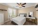Neutral bedroom featuring a white bed, desk, ceiling fan, and a large window with neutral curtains at 5381 Fawn Meadow Ln, Powder Springs, GA 30127
