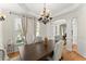 Formal dining room features an elegant chandelier, neutral colors, and crown molding at 5381 Fawn Meadow Ln, Powder Springs, GA 30127