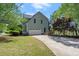 Rear exterior featuring an attached two-car garage and well maintained lawn at 5381 Fawn Meadow Ln, Powder Springs, GA 30127