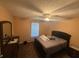 A well-lit bedroom with a queen bed, ceiling fan, and dark wood dresser, creating a comfortable space at 221 Huntington Dr, Mcdonough, GA 30253