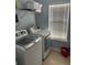 A functional laundry room with modern washer and dryer units, a window, and storage shelves at 221 Huntington Dr, Mcdonough, GA 30253