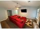 Cozy living room with a ceiling fan, a large television, and comfortable red sectional sofa at 221 Huntington Dr, Mcdonough, GA 30253