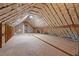 Unfinished attic showing wooden beams and insulation, offering potential for a unique living space conversion at 3860 Rajean Dr, Lawrenceville, GA 30044