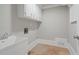 Laundry room featuring a utility sink, white cabinets, and tile floors at 3860 Rajean Dr, Lawrenceville, GA 30044