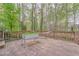 Relaxing back deck with wooden railing and a hammock, surrounded by lush trees at 4327 Saint Michaels Dr, Lilburn, GA 30047