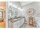 Spacious bathroom with a double sink vanity, a decorative mirror, and a soaking tub with a marble surround at 4327 Saint Michaels Dr, Lilburn, GA 30047