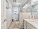 Well-lit bathroom with a toilet, shower, vanity, and a soft rug on the wood look tile floor at 4327 Saint Michaels Dr, Lilburn, GA 30047