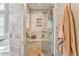Modern bathroom featuring marble tiled walls, glass enclosed shower with a built-in bench and honeycomb tile floor at 4327 Saint Michaels Dr, Lilburn, GA 30047