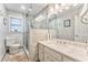 Clean bathroom featuring a toilet, glass-enclosed shower, and a vanity with a light countertop and shaker cabinets at 4327 Saint Michaels Dr, Lilburn, GA 30047