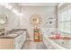 Well-lit bathroom with double sinks, stylish mirrors, shelving, and a relaxing soaking tub by the window at 4327 Saint Michaels Dr, Lilburn, GA 30047
