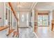 Bright foyer featuring a decorative front door, wood-trimmed stairs, and beautiful chandelier at 4327 Saint Michaels Dr, Lilburn, GA 30047