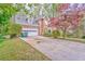 Two-story home with a two-car garage, a paved driveway, and a charming front garden at 4327 Saint Michaels Dr, Lilburn, GA 30047