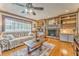 Bright living room featuring a brick fireplace with built-in shelves and hardwood floors at 4327 Saint Michaels Dr, Lilburn, GA 30047