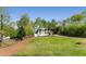 Attractive white home with lush front lawn, mature trees, and charming exterior details, set in a serene neighborhood at 503 Duke Dr, Marietta, GA 30066