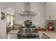 Kitchen close up featuring a stainless steel hood over the range, granite countertops, and subway tile backsplash at 503 Duke Dr, Marietta, GA 30066