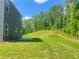 View of a large, lush green backyard surrounded by mature trees, showing ample space at 657 Egrets Landing #54, Covington, GA 30014