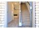 Inviting entryway with a staircase, light wood flooring, and a view into the living room featuring a modern fireplace at 657 Egrets Landing #54, Covington, GA 30014