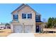 Two-story, light brick home with a two-car garage, black shutters, and a well-manicured lawn on a sunny day at 657 Egrets Landing #54, Covington, GA 30014
