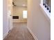 Hallway featuring sleek flooring, modern trim, and views into the living room with a contemporary fireplace at 657 Egrets Landing #54, Covington, GA 30014