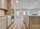 Open kitchen showcasing stainless steel appliances, granite countertops, and wood-look flooring at 657 Egrets Landing #54, Covington, GA 30014