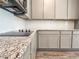 Modern kitchen featuring granite countertops, subway tile backsplash, and gray cabinetry at 657 Egrets Landing #54, Covington, GA 30014