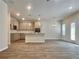 Open-concept living space with modern kitchen, stylish light fixtures, and elegant wood-look flooring at 657 Egrets Landing #54, Covington, GA 30014