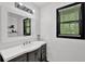 Modern bathroom with a sleek vanity, decorative mirror, and ample natural light at 2451 Cedar Fork Trl, Marietta, GA 30062