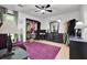A cozy bedroom featuring a black closet, an accent purple rug and chair, and a well-lit window at 2451 Cedar Fork Trl, Marietta, GA 30062