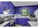 Kitchen featuring bright blue cabinets, stainless steel appliances, and natural light at 2451 Cedar Fork Trl, Marietta, GA 30062