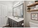 Bathroom featuring dual sinks, a large mirror, and decorative shelves at 2894 Cross Creek Dr, Cumming, GA 30040