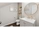 Cozy bathroom featuring a round mirror, modern vanity, and decorative shelving and pictures at 2894 Cross Creek Dr, Cumming, GA 30040