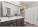 Bathroom featuring dual sinks, a large mirror, and an adjacent bathtub with a shower curtain at 2894 Cross Creek Dr, Cumming, GA 30040