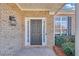 Close-up of the home's entryway, featuring a brick facade, a black door, and sidelight windows at 5013 Centennial Commons Nw Dr, Acworth, GA 30102