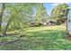 Spacious backyard featuring a lush lawn, mature trees, wooden fence and multi-level deck at 60 Bartlett Way, Dallas, GA 30157