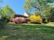 Lush backyard featuring mature trees, colorful bushes, and a terraced slope with beautiful landscaping at 60 Bartlett Way, Dallas, GA 30157