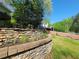 Backyard with retaining wall, grass, and view of wooded property at 60 Bartlett Way, Dallas, GA 30157