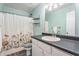 Bathroom features a floral shower curtain, granite counter, and new faucet at 60 Bartlett Way, Dallas, GA 30157