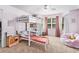 Spacious pink bedroom features a bunk bed with desk, a pink beanbag chair, and natural light at 60 Bartlett Way, Dallas, GA 30157